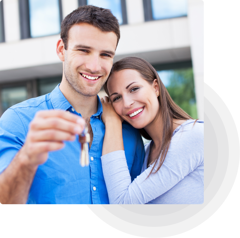 Happy couple holding house keys, celebrating their new home purchase