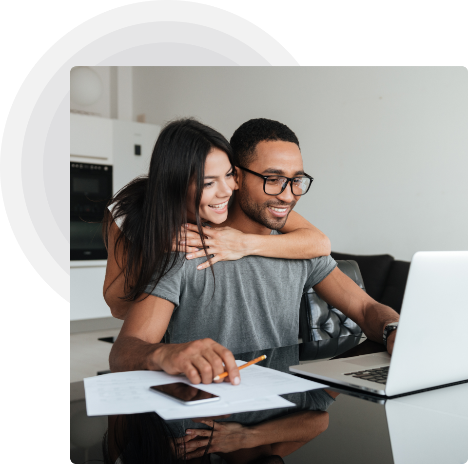 Joyful couple using a laptop together, engaged in an online activity
